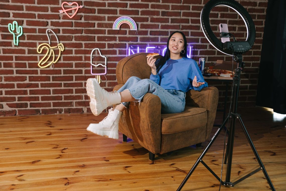 a woman recording herself with a smartphone while eating